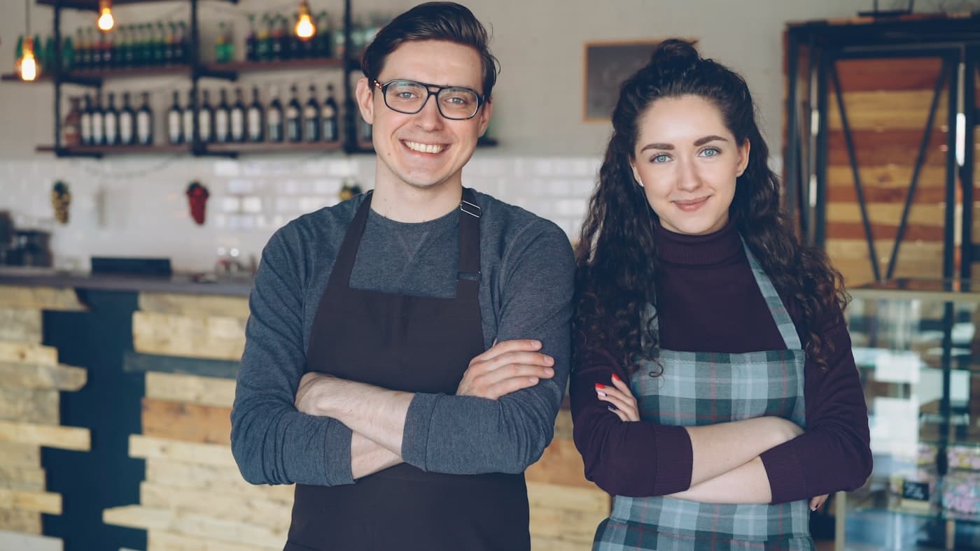 Casal de donos de uma cafeteria atrás do balcão